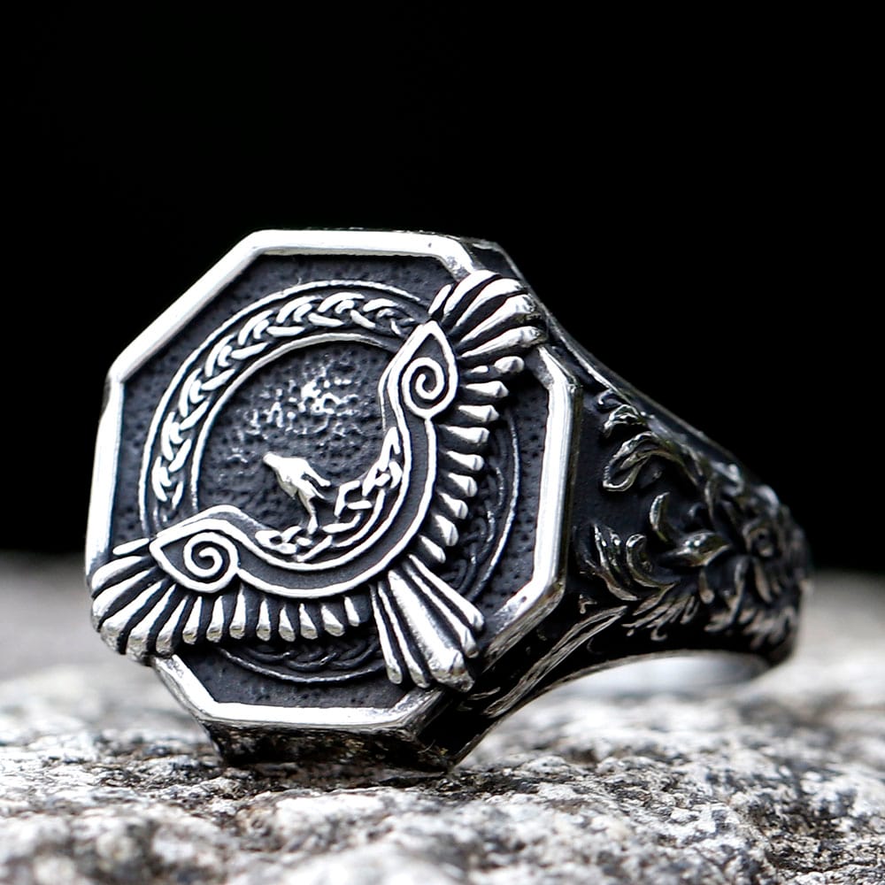 Oxidized 316L stainless steel Norse flying eagle ring on a textured stone surface.