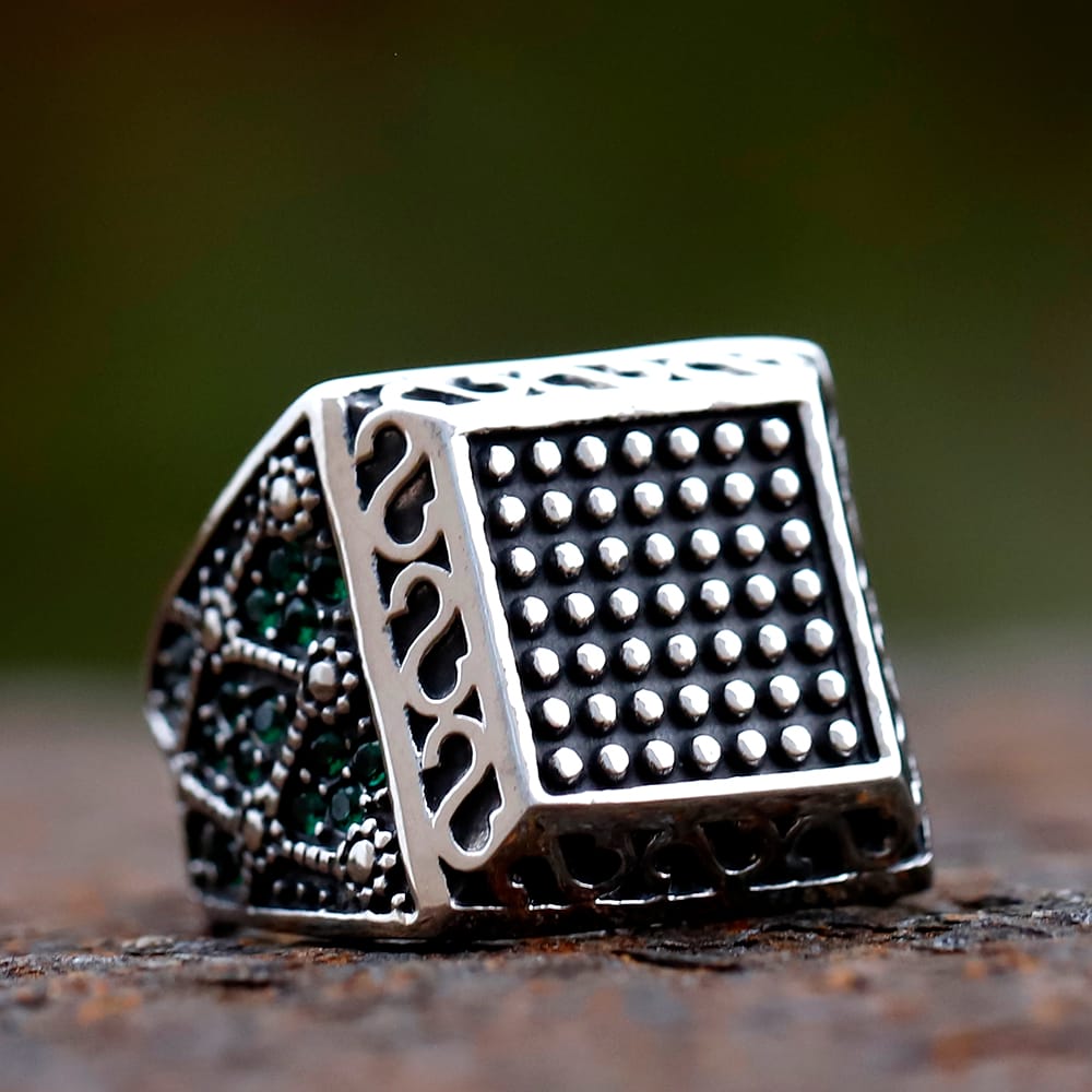 Angled perspective showcasing the oxidized antique finish and green zircon side detailing