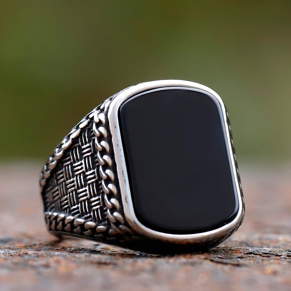 Close-up of a men's vintage punk stainless steel ring with a rectangular black stone.