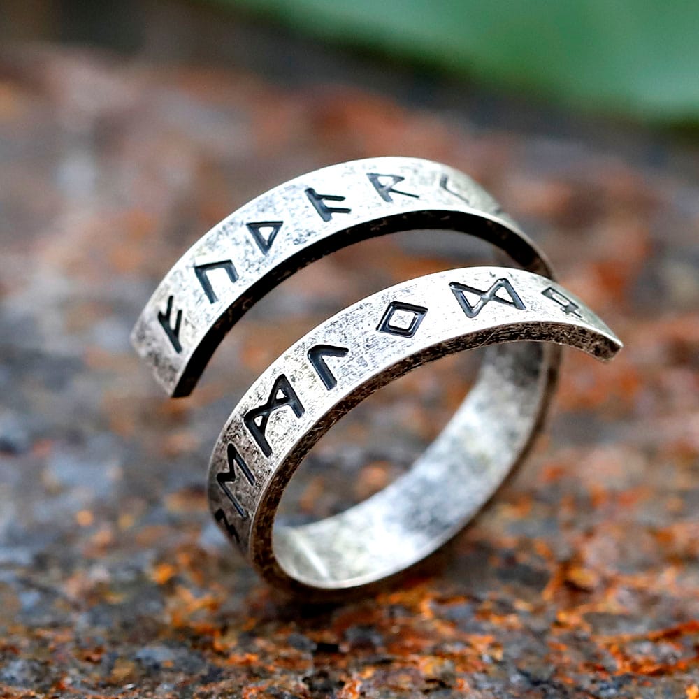 Close-up of the 316L stainless steel Viking rune ring, showing etched Elder Futhark runes on a rustic surface.