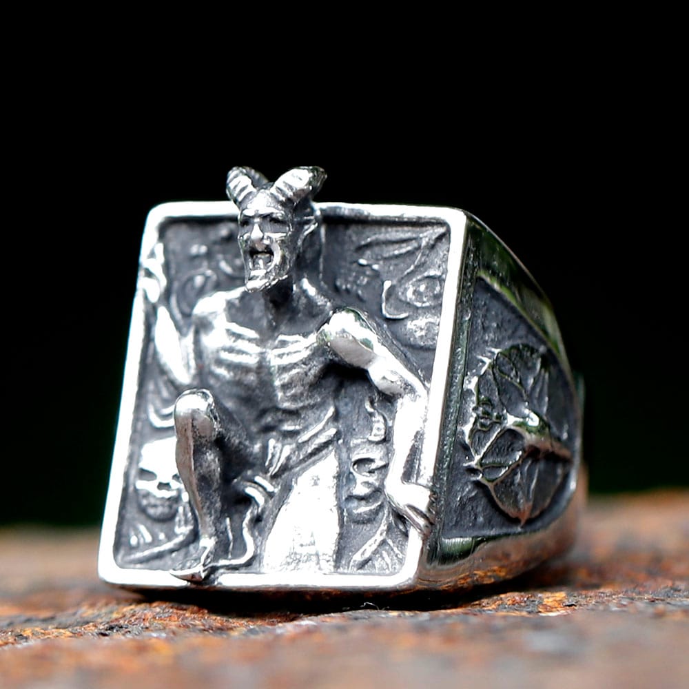 Close-up detail of the horned demon figure and skulls on the face of the gothic steel ring