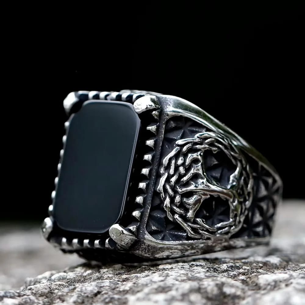 Stainless steel ring with an antique finish, featuring a rectangular black stone centerpiece and an intricately carved Yggdrasil design on the side.