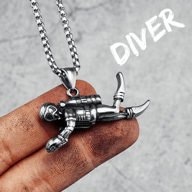 Detailed 316L stainless steel scuba diver pendant on a chain, held by hand.