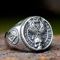 Angled perspective of the stainless steel Gothic ring, showing the skull and part of the 'BE SILENT' motto.