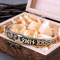 Close-up of the gold-tone Mjolnir and Norse runes on the antiqued steel cuff bracelet