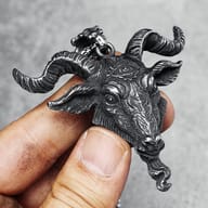 Side profile close-up of the ram goat head pendant, showcasing its textured fur and eye detail.