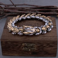 Two-tone Viking dragon keel stainless steel bracelet resting on a wooden box