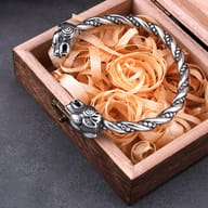 Close up of sculpted goat head terminals on a twisted stainless steel cuff bracelet