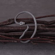Detailed close-up of textured scales and serpent head on stainless steel ear wrap