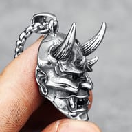 Close-up of the Hannya mask pendant with its chain link and bail.