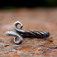 Detail view of the top spiral curve of the 316L stainless steel Troll Cross ring.