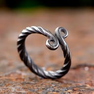 Lower curve of the Viking Troll Cross ring showing twisted stainless steel texture.