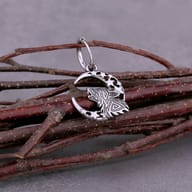 Detailed view of the intricate tribal knotwork engraving on the howling wolf charm