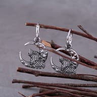 Close-up view of the detailed carved wolf and star-accented crescent moon pendant on hoop clasp