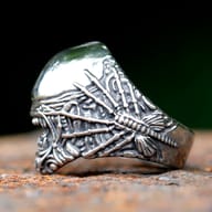 Angled close-up of xenomorph-inspired skull ring showing textured jaw and dome