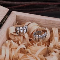 Two Gothic Vampire Teeth 316L Stainless Steel Non-Piercing Ear Cuffs in a rustic wooden setting.