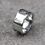 Detailed view of the side engraving, including a rose and abstract pattern, on the left side of the stainless steel skull ring band.
