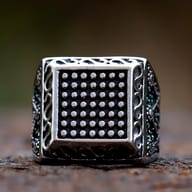 Close-up view of the studded square face on a 316L stainless steel signet ring