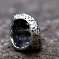 Frontal detail of the skull and clenched fist design on the stainless steel ring.