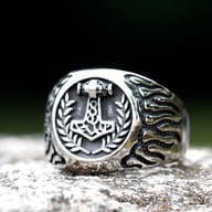 Angled shot emphasizing the robust band and the central Mjolnir design on the ring.
