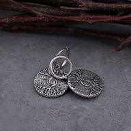 Angled view of the Tree of Life stainless steel pendant, emphasizing its metallic sheen and texture.