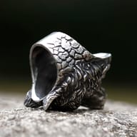 Another angle of the wolf head ring, illustrating its overall solid construction and detailed carving on a natural background.