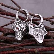 Detailed close-up of the Viking wolf head earring charm with red crystal eyes and textured metal detailing