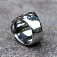 Macro shot revealing the detailed side of the skull ring, with darkened accents enhancing its rugged texture and visual depth.