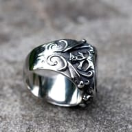Detail shot of the top section of the men's gothic skull ring, highlighting the smooth oval face and ornate frame.