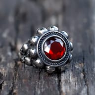 Close-up of the top portion of the gothic skull ring, highlighting the red zircon and surrounding details.