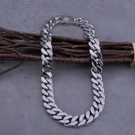 Close-up of the engraved Valknut clasp on the polished stainless steel Cuban link chain