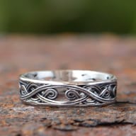Side view of a detailed Viking Celtic knot ring on a dark surface.