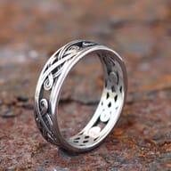 Openwork Celtic knot ring on a natural, textured background.