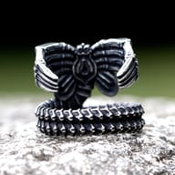 Gothic Alien Creature ring displayed on a rugged surface, highlighting its dark aesthetic