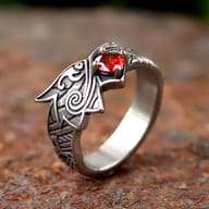 Stainless Steel Viking Dragon Ring with red zircon eye on a rustic background