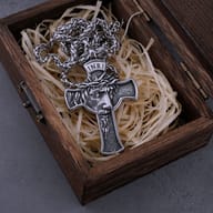Close-up profile of the finely detailed Jesus face and crown of thorns on the stainless steel cross pendant.