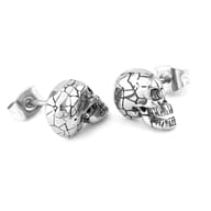 Stainless steel skull stud earring shown in hand for scale and proportion