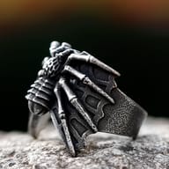 Close-up detail of the spider's textured head on a men's gothic ring against a dark background.