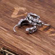 Pair of gothic skull hoop earrings in stainless steel on wooden background