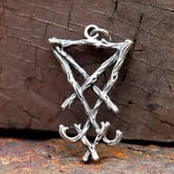 Sigil of Lucifer pendant with branch texture resting on rustic wood