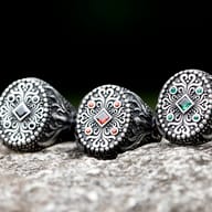 Angled view of the durable 316L stainless steel men's ring, emphasizing its robust build and green gems.
