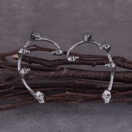 Pair of gothic skull elf ear cuff wrap earrings displayed on rustic branches