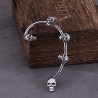 Close up of detailed miniature skulls and textured band on stainless steel ear cuff