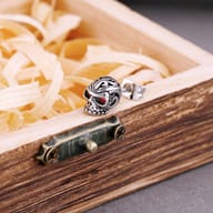 Detailed view of the intricate hollow filigree pattern on the top of the skull stud