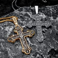 Top portion of the Jesus cross pendant with ornate details, against a grey background.