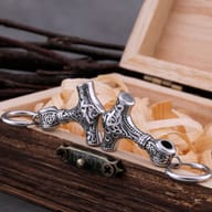 Close-up of Norse Mjolnir earrings showing intricate Celtic knotwork carving