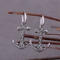 Pair of vintage Viking anchor drop hoop earrings in stainless steel hanging on a branch
