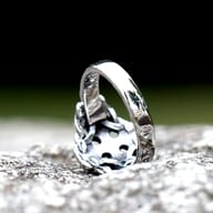 Celtic knotwork cross ring resting flat against a dark textured background