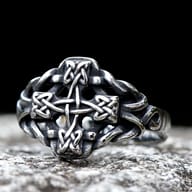 Front view of the 316L stainless steel Celtic cross knot ring on a stone surface