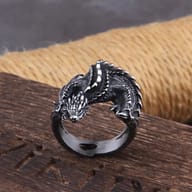The formidable stainless steel dragon ring displayed on a rustic wooden surface